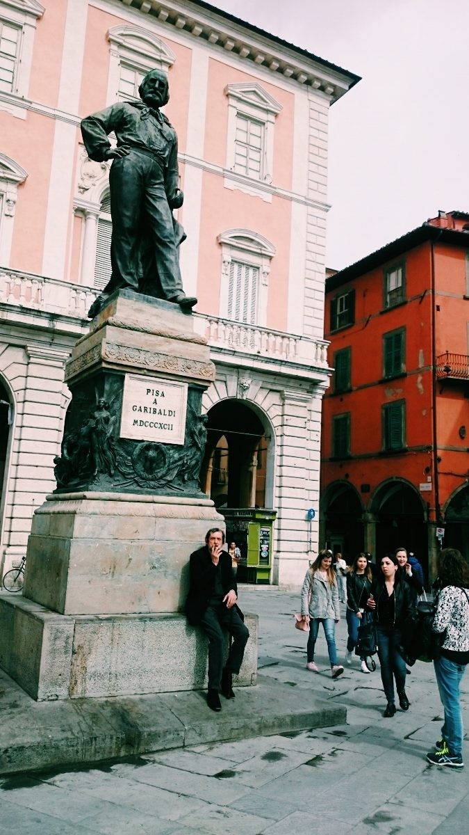Man sitting on the monument in Pisa